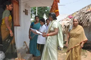 Adults exchanging a document at the entrance to a home.
